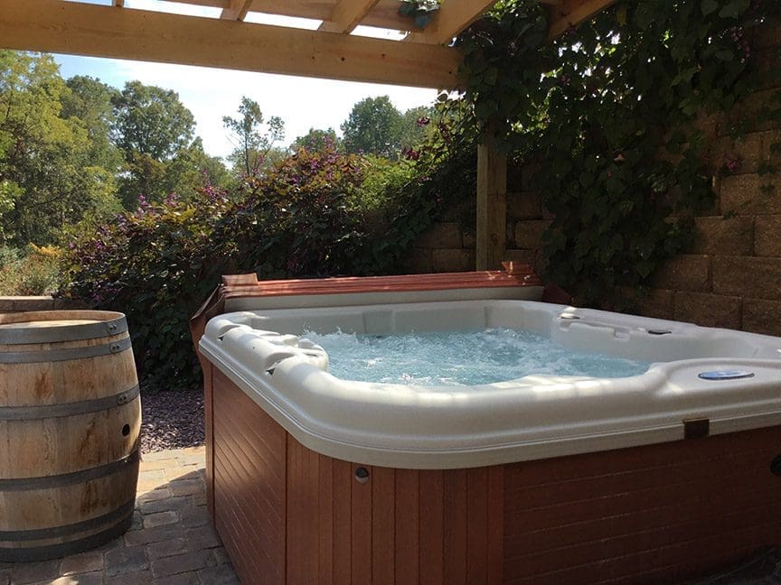A hot tub is sitting in the middle of an outdoor patio.
