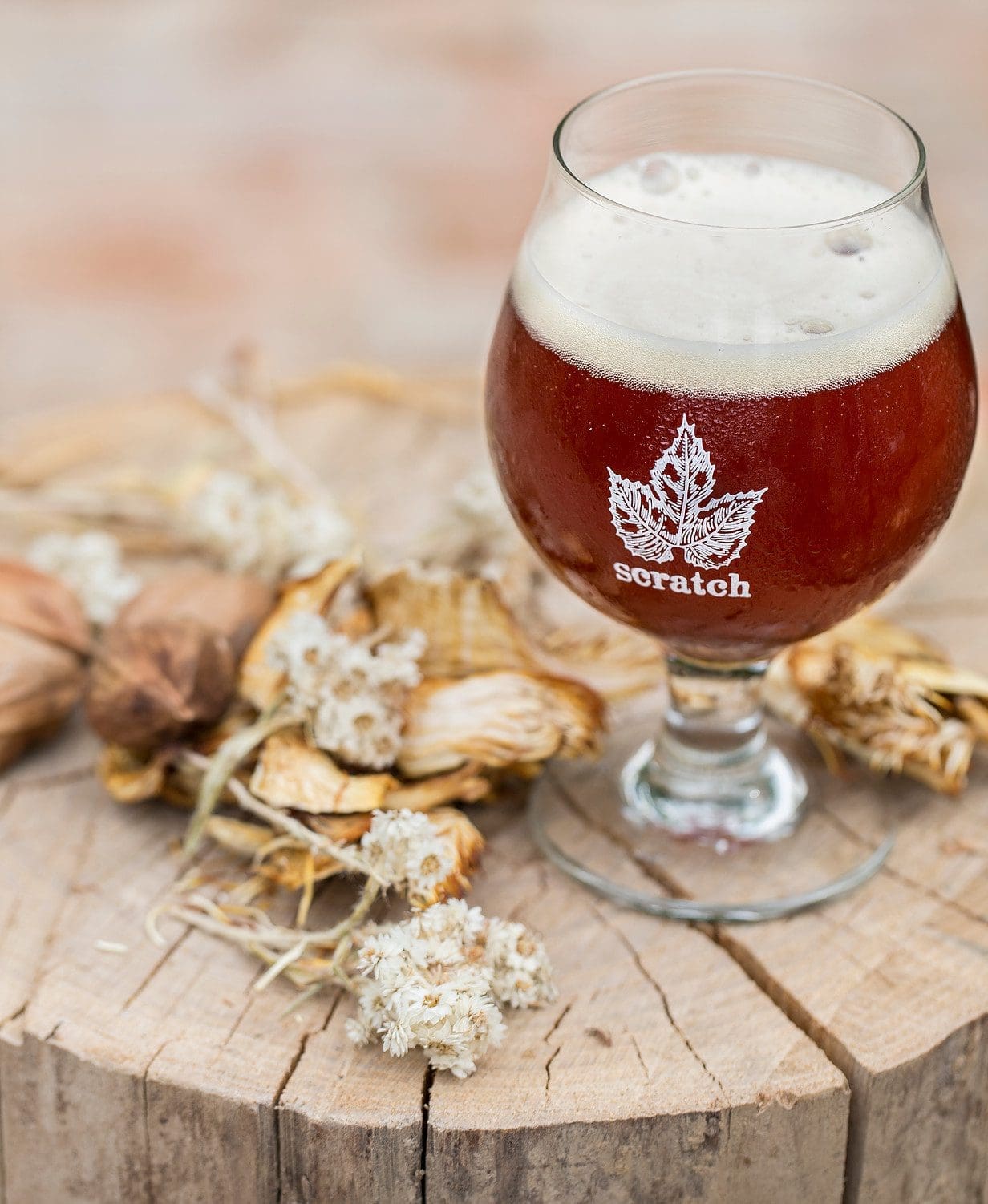 A glass of beer on top of a wooden table.