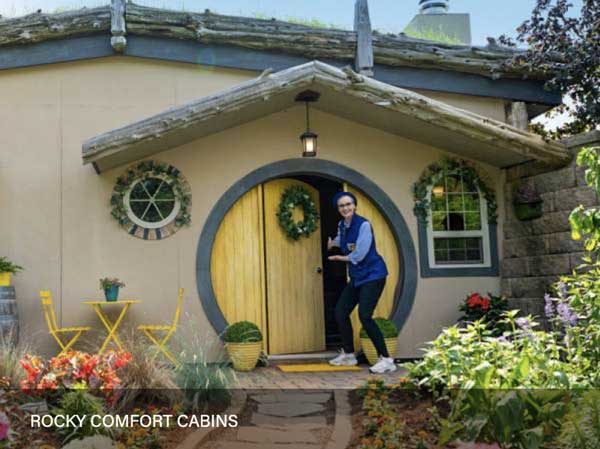 Jane Lynch visiting Rocky Comfort Cabins standing in front of a the round yellow door.