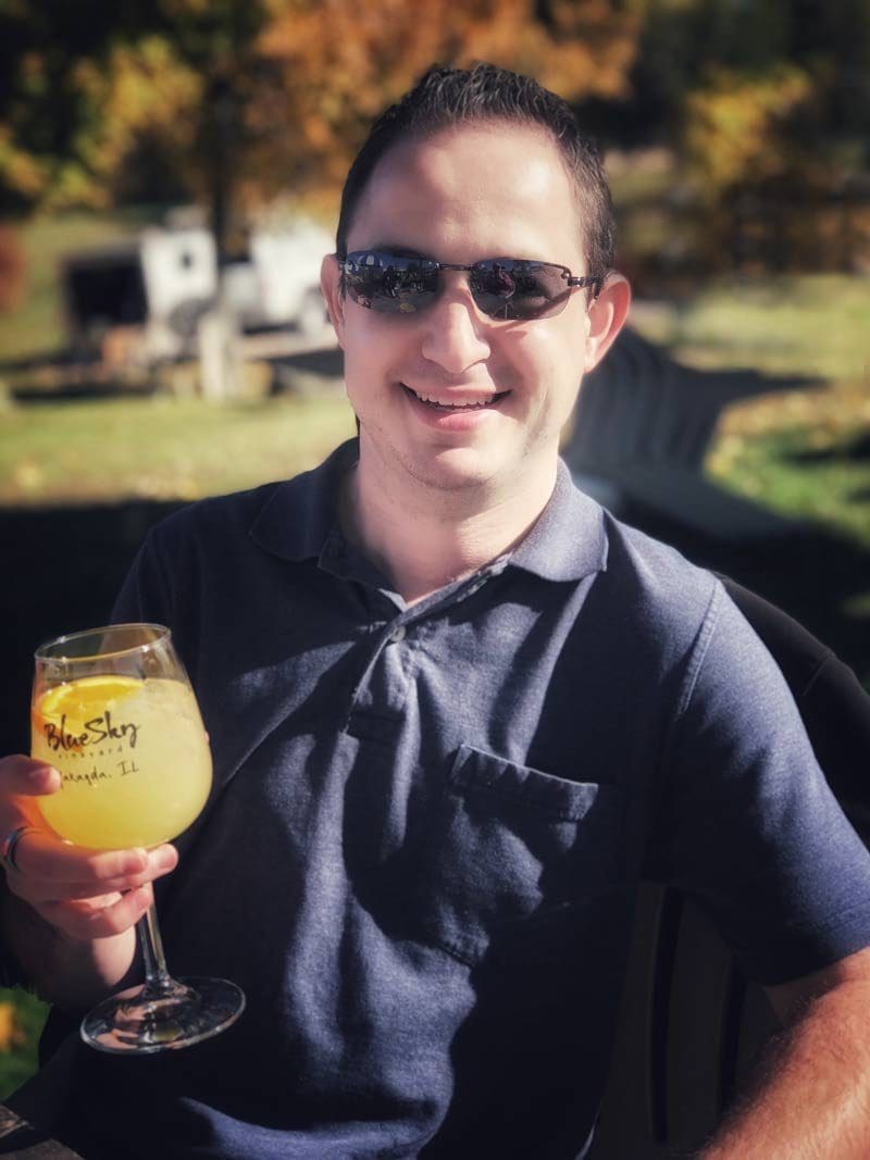 A man holding up a glass of orange juice.