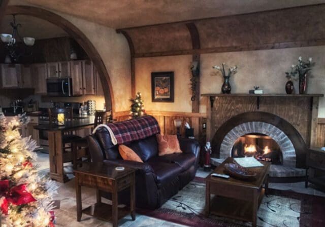 Cozy cabin with a leather couch, curved walls, and gas fireplace